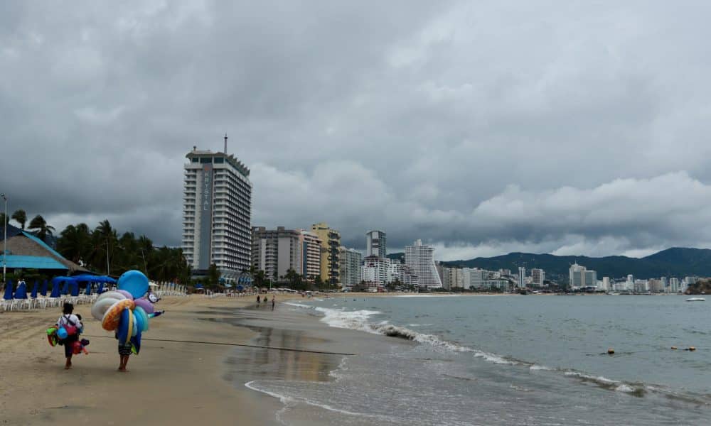 Vendedores caminan en una playa de Acapulco (México). Imagen de archivo. EFE/David Guzmán