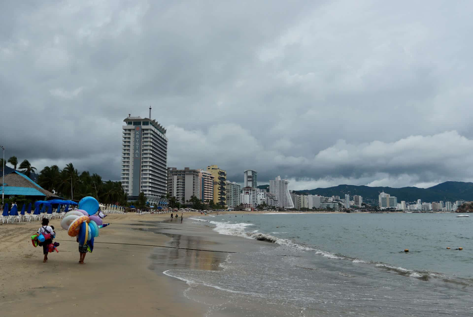 Vendedores caminan en una playa de Acapulco (México). Imagen de archivo. EFE/David Guzmán