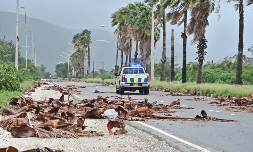 Un vehículo de la policía patrulla una carretera llena de escombros de árboles debido al paso del huracán Melissa, en Kingston (Jamaica). EFE/Rudolph Brown