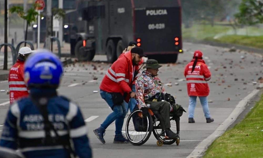 Fotografía tomada de la cuenta en X @SeguridadBOG de la Secretaría de Seguridad de Bogotá de un gestor de convivencia acompañando a una persona en silla de ruedas este viernes, durante una protesta en Bogotá (Colombia). EFE/ Secretaría de Seguridad de Bogotá