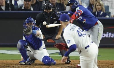 El primera base de los Azulejos de Toronto Vladimir Guerrero Jr. (d), conecta un sencillo contra el lanzador de los Los Angeles Dodgers, Blake Treinen (2-i), durante la séptima entrada del juego tres de la Serie Mundial de MLB. EFE/EPA/CAROLINE BREHMAN