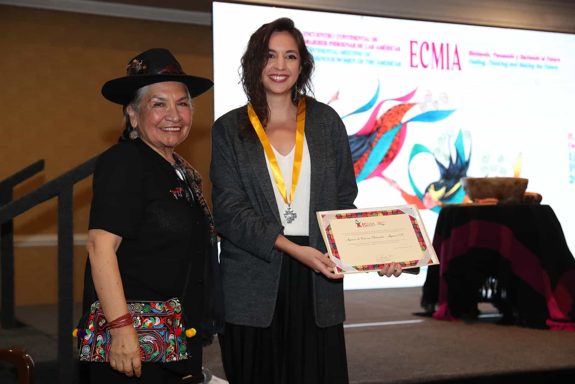 La líder Indígena, Tarcila Rivera, entrega un reconocimiento a la periodista de EFE, Paula Bayarte (d), en representación de Efeminista, este jueves, en Lima (Perú). EFE/ Paolo Aguilar