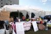 Personas hablan en una carpa que ofrece información sobre las protestas contra el Servicio de Inmigración y Control de Aduanas (ICE) afuera del centro de detención del ICE este miércoles, en Broadview (Estados Unidos). EFE/ Manuel Márquez
