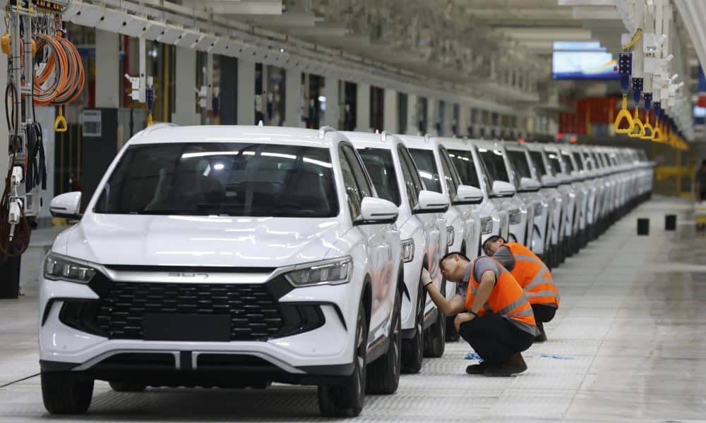 Personas limpian vehículos durante la inauguración de la fábrica de la empresa china Build Your Dreams (BYD), que será la base de la futura expansión en el mercado de vehículos eléctricos de América Latina este jueves, en Camaçari (Brasil). EFE/ Américo Roberto