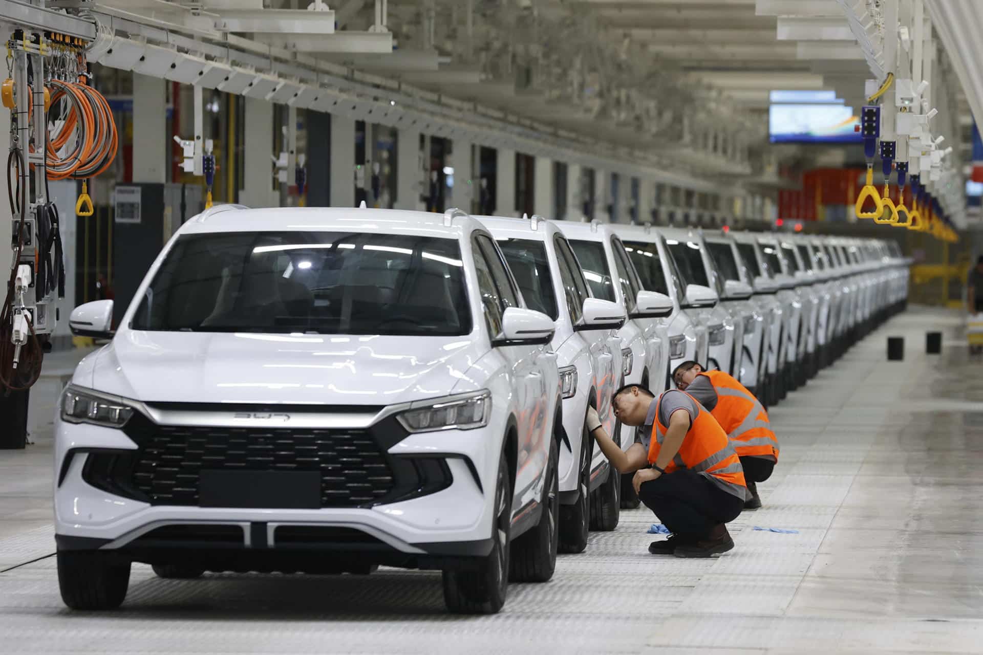 Personas limpian vehículos durante la inauguración de la fábrica de la empresa china Build Your Dreams (BYD), que será la base de la futura expansión en el mercado de vehículos eléctricos de América Latina este jueves, en Camaçari (Brasil). EFE/ Américo Roberto