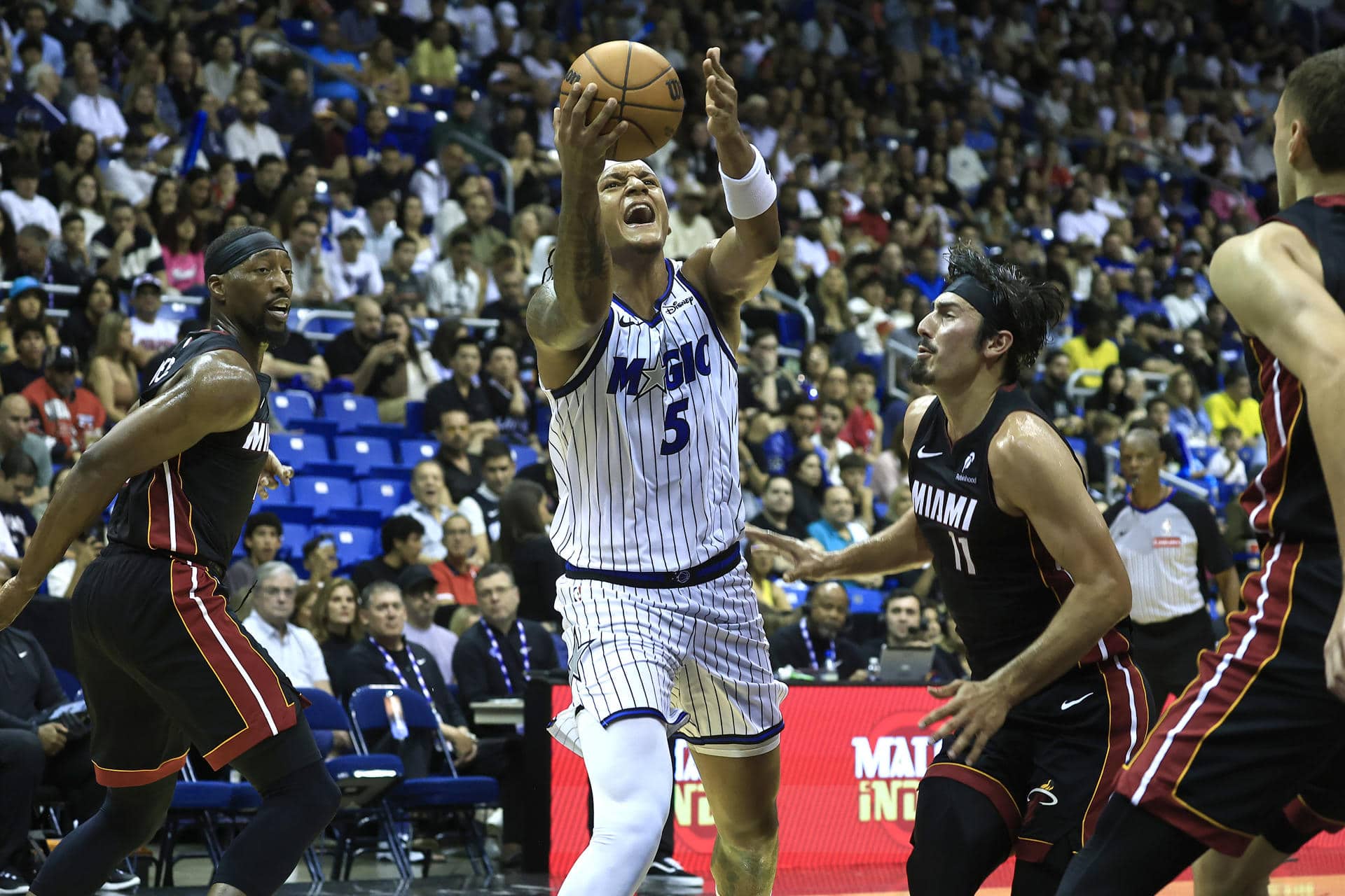 Paolo Benchero (c) de Orlando Magic se eleva entre jugadores del Miami Heat este sábado, en un partido de la pretemporada de la NBA jugado en en el Coliseo José Miguel Agrelot, de San Juan. EFE/ Thais Llorca