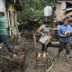 Personas caminan frente a casas afectadas por inundaciones en la aldea Rio Abajo este viernes, en Tegucigalpa (Honduras).EFE/ Gustavo Amador