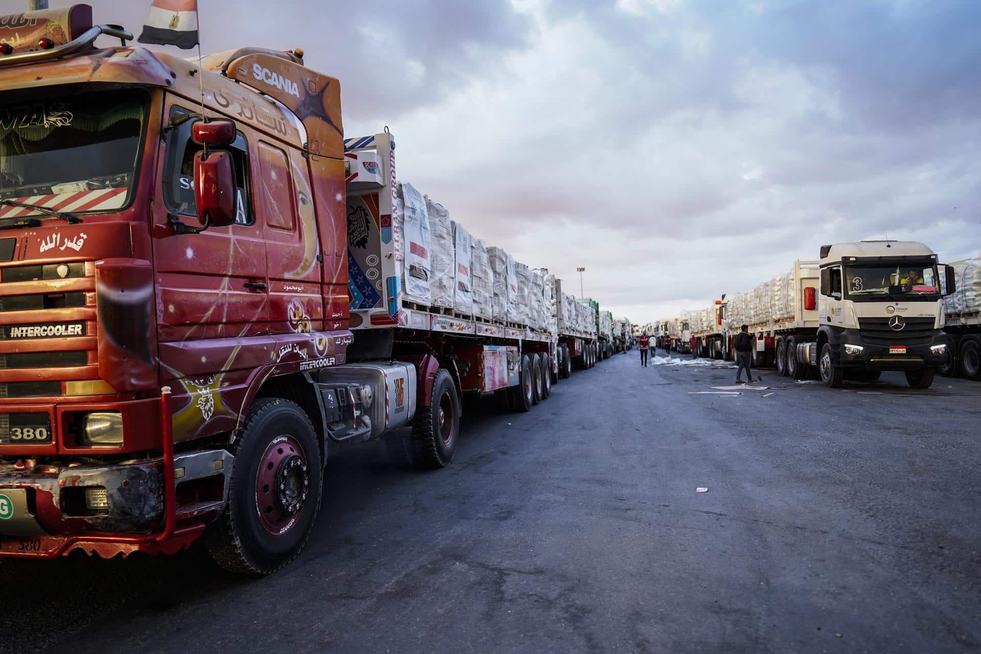 Camiones cargados con ayuda humanitaria esperan para salir hacia Gaza desde la parte egipcia del paso fronterizo de Rafah, entre Egipto y la franja de Gaza, este domingo. Israel y Hamás acordaron el 8 de octubre de 2025 firmar la primera fase de un marco de paz que permitirá la rápida liberación de todos los rehenes. EFE/ Stringer