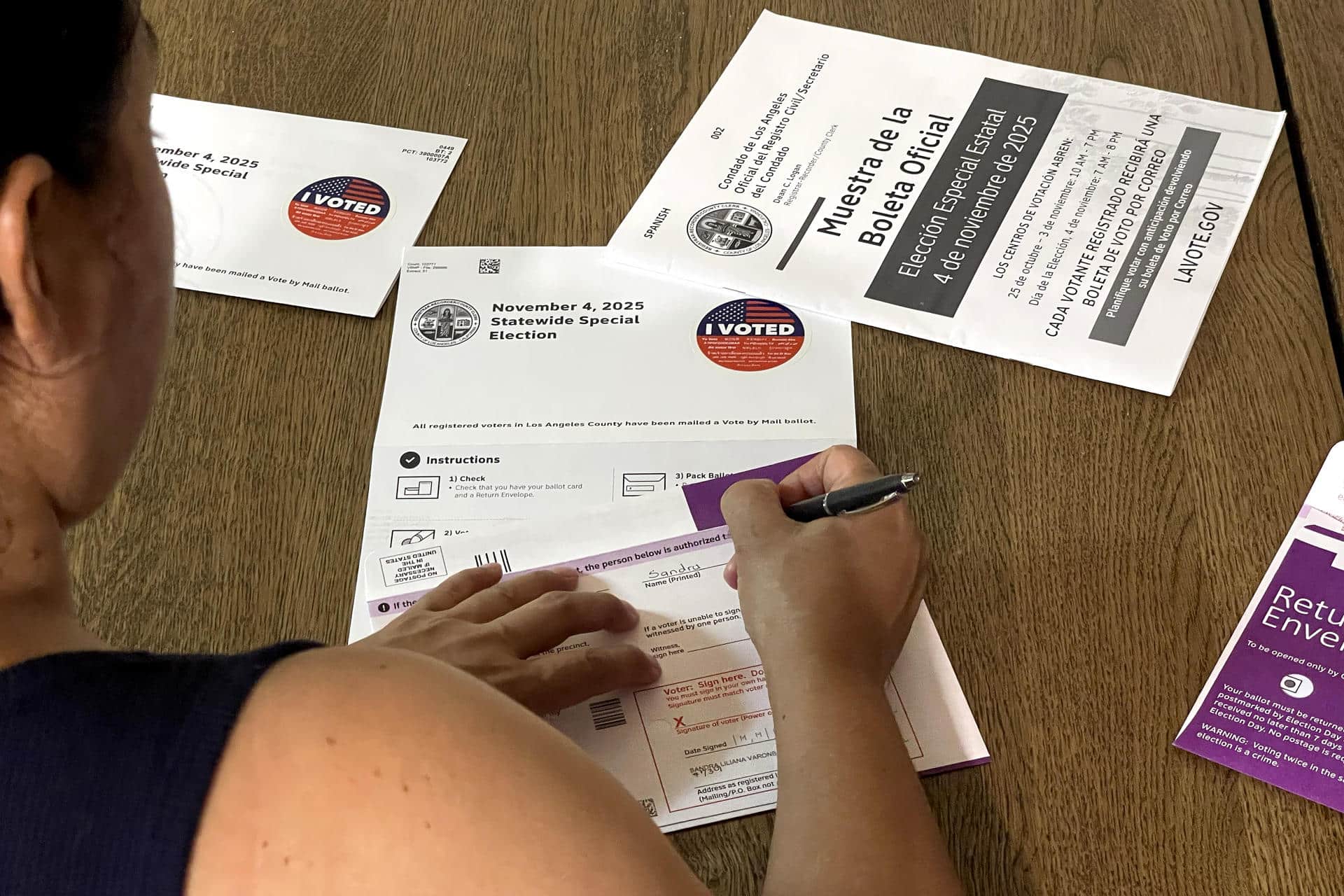 Una persona llena una boleta por correo de les elecciones especiales estatales de California este miércoles, en Los Ángeles (EE.UU.). EFE/ Ana Milena Varón