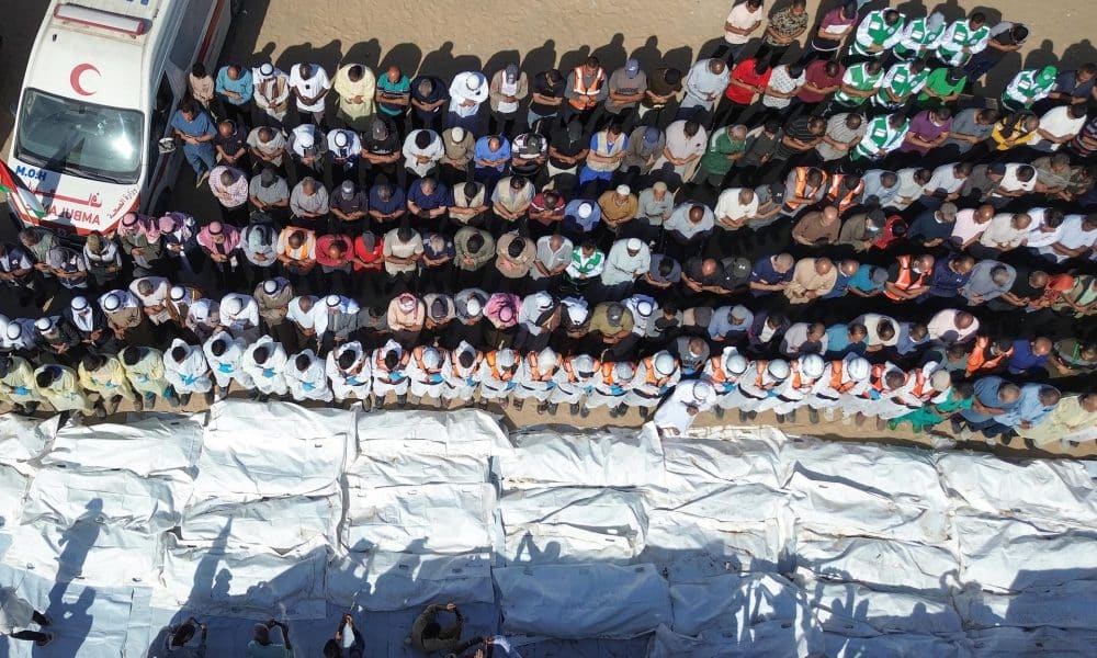 Equipos médicos rezan junto a los restos y cuerpos de palestinos no identificados, devueltos por Israel, antes de su entierro masivo fuera del Hospital Nasser en Khan Yunis, Franja de Gaza sur, 22 de octubre de 2025. La devolución de prisioneros palestinos fallecidos por Israel forma parte de un acuerdo de alto el fuego entre Israel y Hamas que entró en vigor el 10 de octubre de 2025. EFE/EPA/HAITHAM IMAD