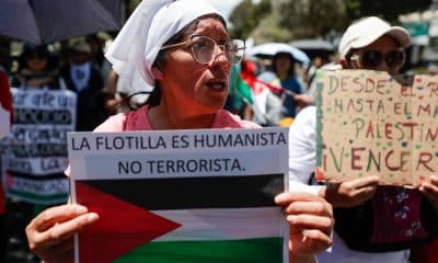 Una persona sostiene un cartel durante la segunda peregrinación por la paz en Palestina este domingo, en Quito (Ecuador). EFE/José Jácome