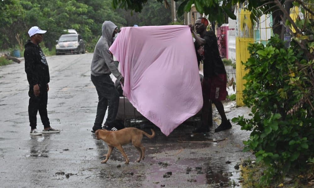 Personas cubren una mesa antes del paso del huracán Melissa este lunes, en la playa pesquera de Hellshire, en Portmore (Jamaica). EFE/Rudolph Brown