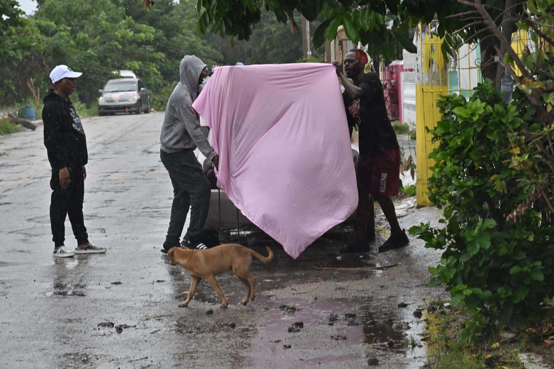 Personas cubren una mesa antes del paso del huracán Melissa este lunes, en la playa pesquera de Hellshire, en Portmore (Jamaica). EFE/Rudolph Brown