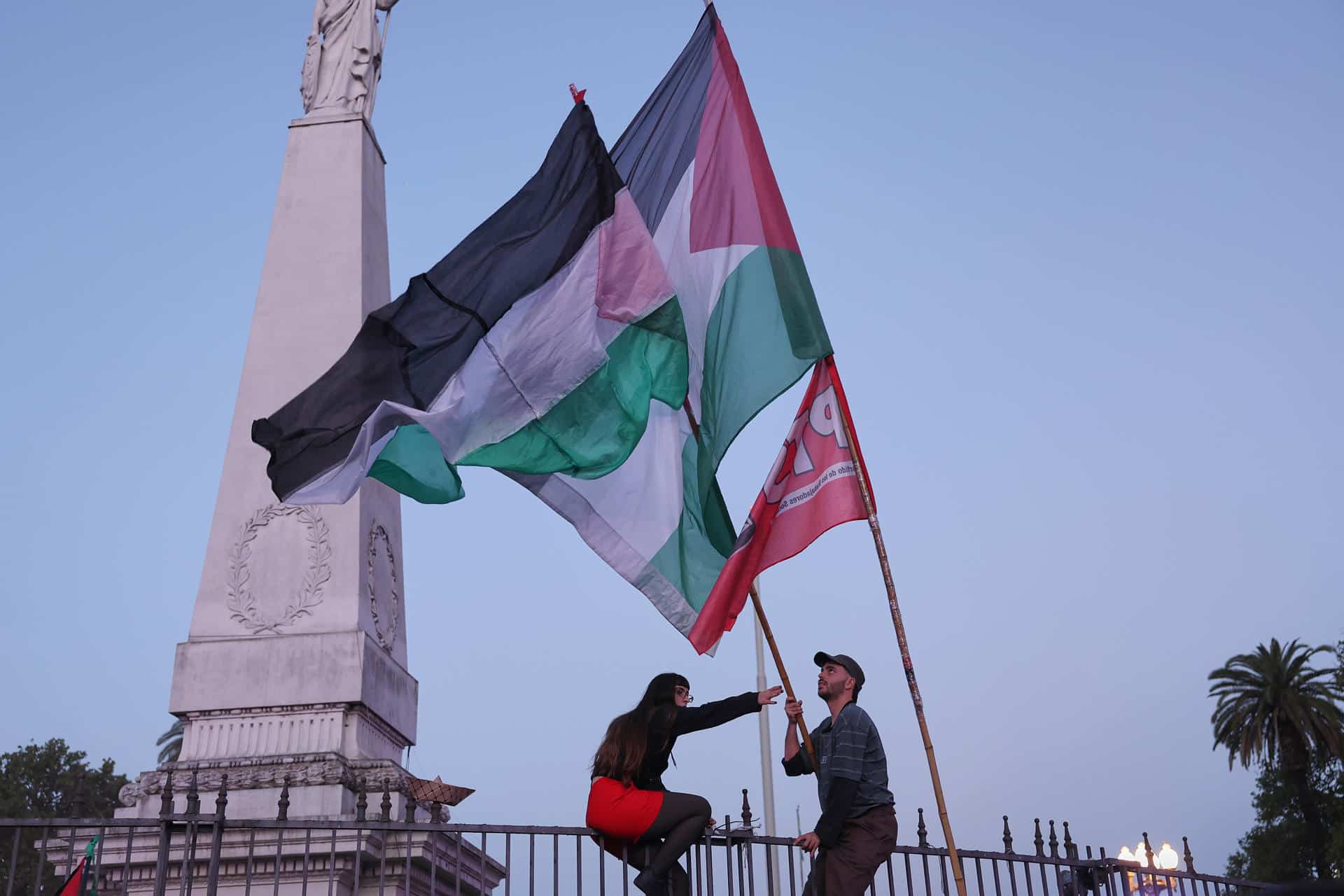 Personas sostienen banderas en una manifestación en apoyo a Palestina este martes, en Buenos Aires (Argentina). Miles de personas marcharon bajo la consigna "basta de genocidio" en la Franja de Gaza a dos años del ataque del grupo islamista Hamás contra Israel y el comienzo de la guerra en el enclave palestino. EFE/ STR