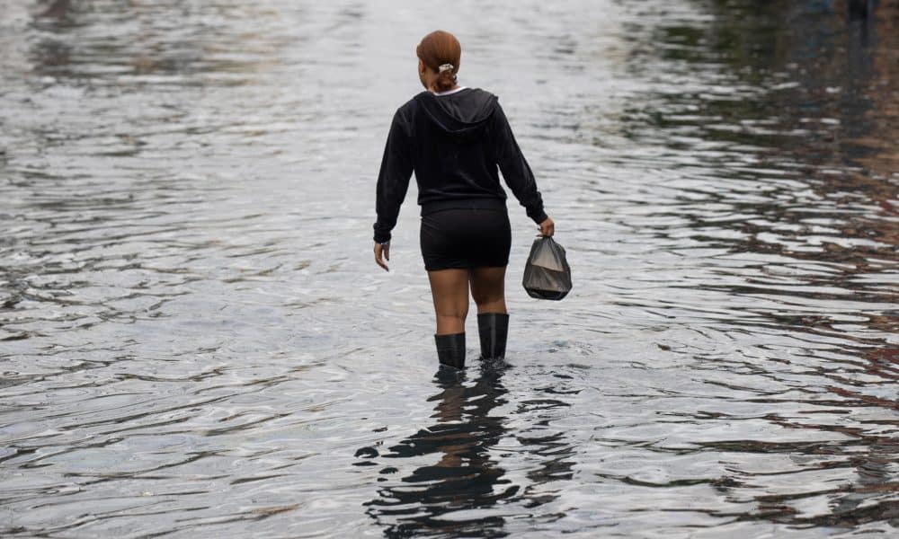 Una mujer camina por una zona inundada este jueves, en Santo Domingo (República Dominicana). EFE/ Orlando Barría