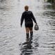 Una mujer camina por una zona inundada este jueves, en Santo Domingo (República Dominicana). EFE/ Orlando Barría