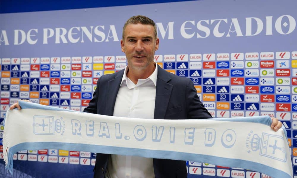 El nuevo entrenador del Oviedo, Luis Carrión, posa con una bufanda del club durante su presentación oficial, este viernes en el estadio Carlos Tartiere de la capital asturiana. EFE/Paco Paredes