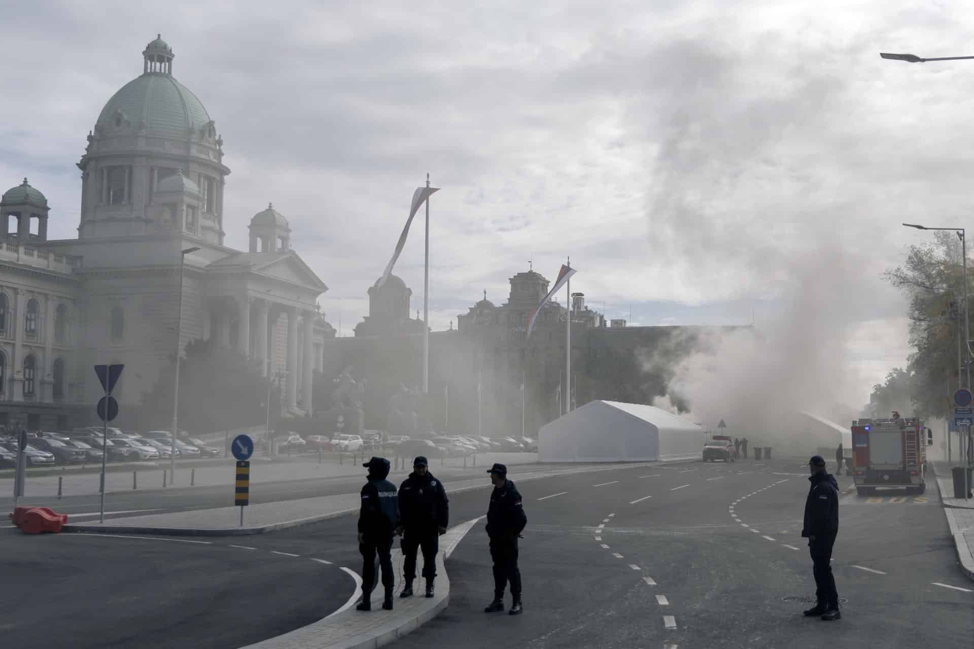los oficiales aseguran la escena frente al edificio del Parlamento mientras el humo sale de una carpa, en Belgrado, Serbia, 22 de octubre de 2025. Un hombre resultó gravemente herido en un incidente de disparos fuera del edificio del parlamento, cerca de una carpa de partidarios del presidente Vucic, quien describió el incidente como un 'acto terrorista'. Una persona fue detenida en relación con el tiroteo. (Terrorista, Belgrado) EFE/EPA/STRINGER