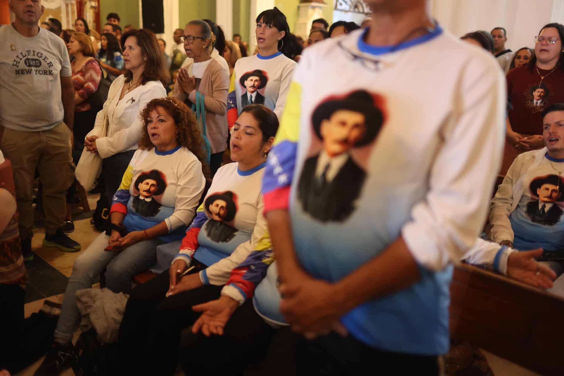 Fieles con camisetas con la imagen del médico José Gregorio Hernández rezaban en la Iglesia de la Candelaria este sábado, en Caracas (Venezuela) esperando su canonización y la de Carmen Rendiles, primeros santos del país. EFE/ Miguel Gutiérrez