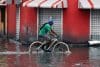Un hombre en bicicleta cruza por una zona inundada este jueves, en Santo Domingo (República Dominicana). EFE/ Orlando Barría