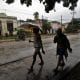 Personas se protegen de la lluvia este martes, en Santiago de Cuba (Cuba). EFE/ Ernesto Mastrascusa