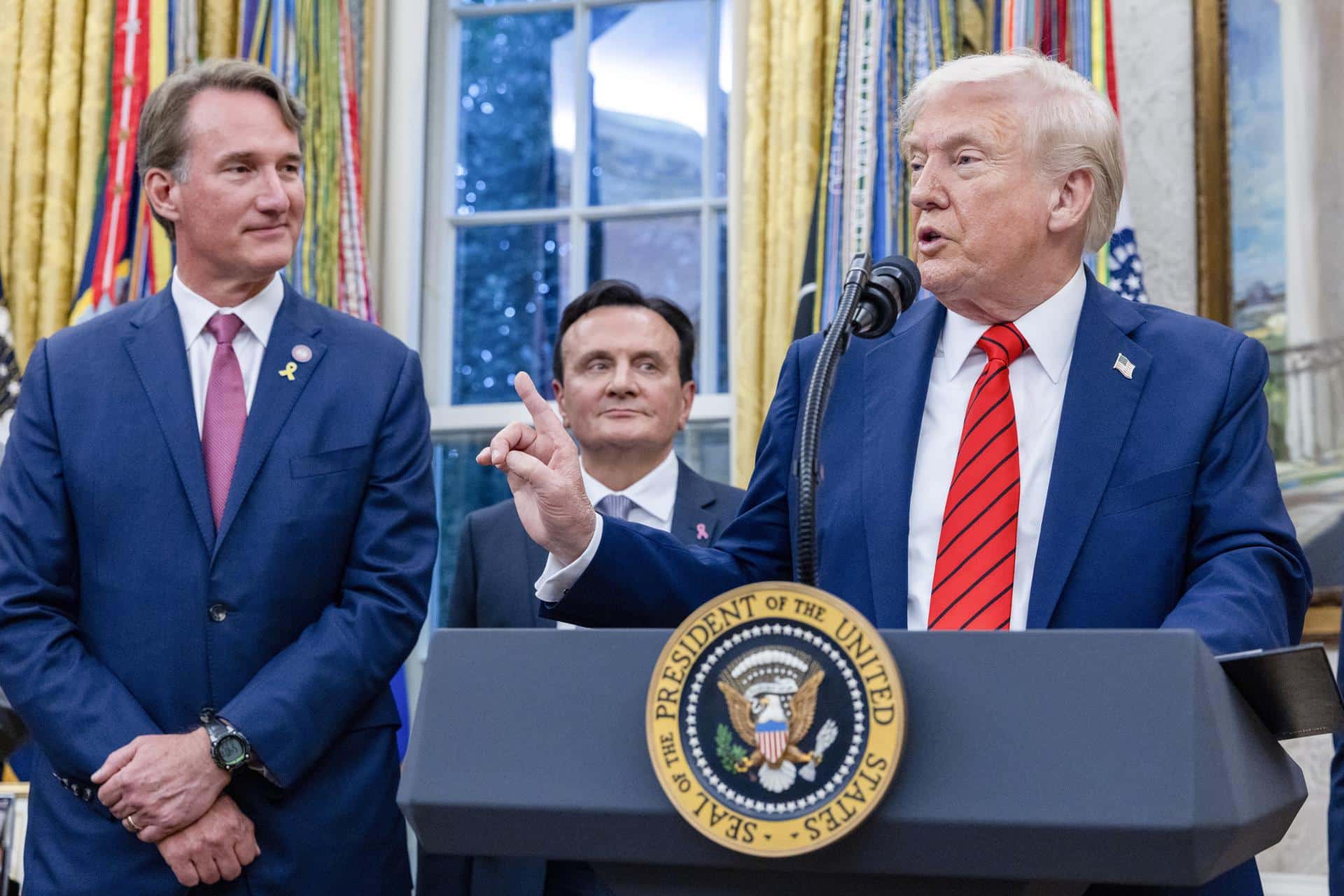 El presidente de EE.UU., Donald Trump, junto con el gobernador de Virginia, Glenn Youngkin (izq.), y el director ejecutivo de AstraZeneca, Pascal Soriot (centro), ofrece declaraciones durante el anuncio de un acuerdo sobre precios de medicamentos en una conferencia de prensa en el Despacho Oval de la Casa Blanca, en Washington D.C., EE. UU., el 10 de octubre de 2025. EFE/EPA/SHAWN THEW / POOL