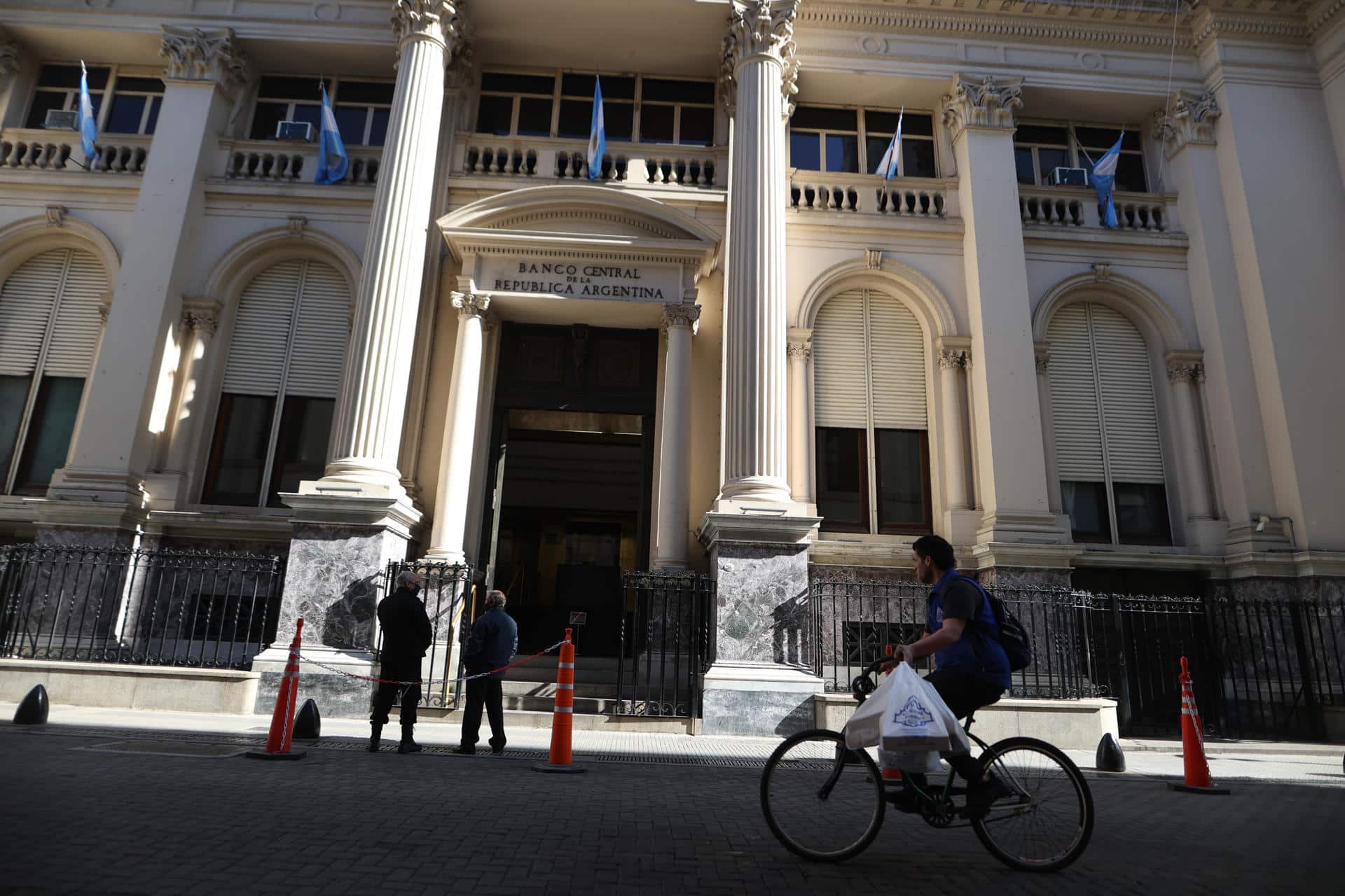 Varias personas cruzan frente a la sede del Banco Central de la República Argentina, en una fotografía de archivo. EFE/ Juan Ignacio Roncoroni