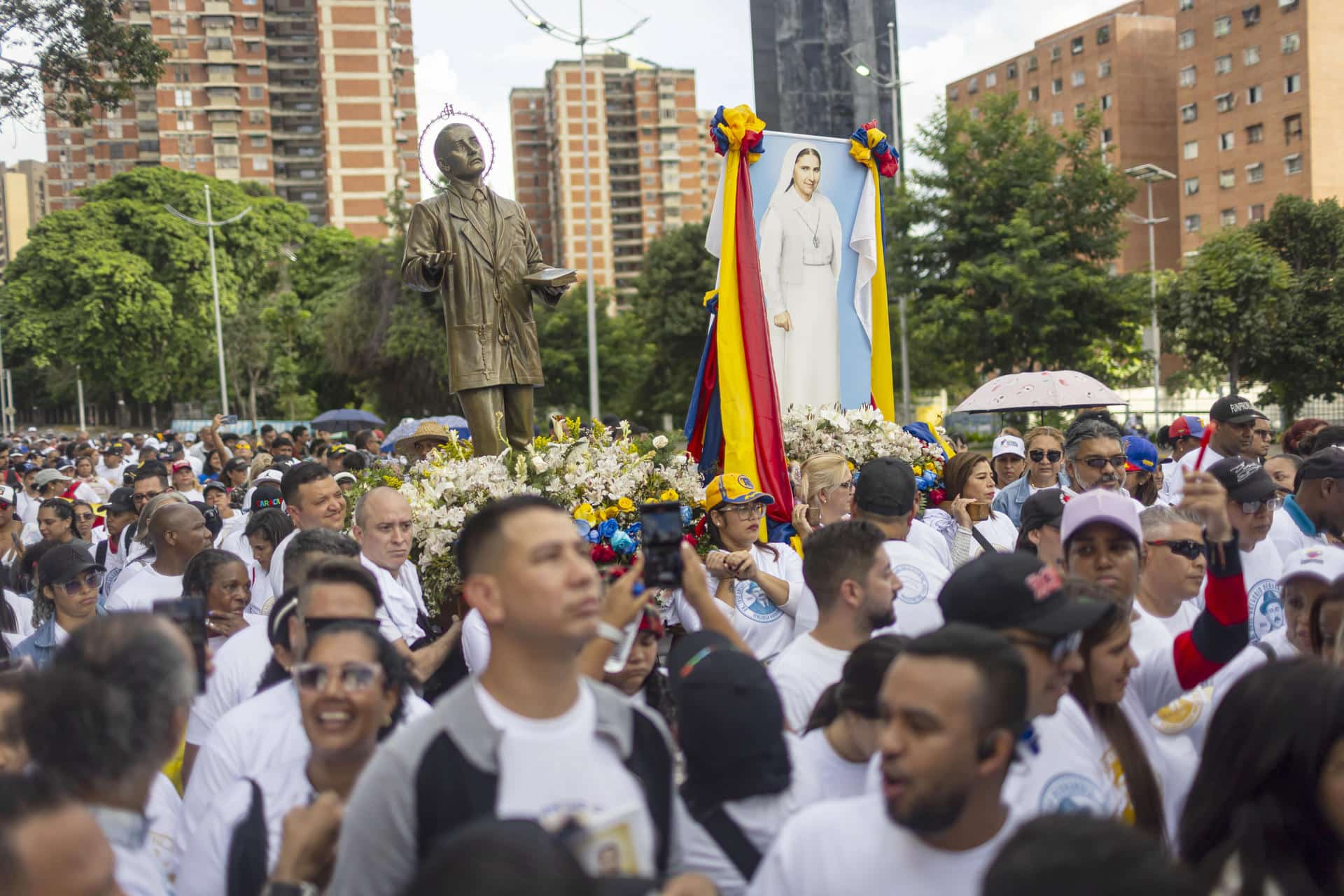 Personas participan en una marcha para celebrar la canonización de los primeros dos santos venezolanos, el médico José Gregorio Hernández y la religiosa Carmen Rendiles este miércoles, en Caracas (Venezuela). EFE/ Miguel Gutiérrez