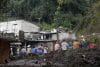 Personas observan una zona afectada por las fuertes lluvias este domingo, en Huauchinango (México). EFE/ Hilda Ríos
