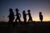 Niños palestinos juegan al atardecer frente a sus tiendas en Khan Younis, en la Franja de Gaza sur, el 25 de octubre de 2025. 
EFE/EPA/HAITHAM IMAD