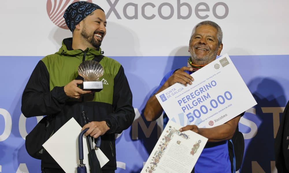 El colombiano Jairo Forero y su hijo Nicolás con el certificado del peregrino 500.000 del Camino de Santiago en la ciudad de Santiago de Compostela (España) . EFE/Lavandeira jr.