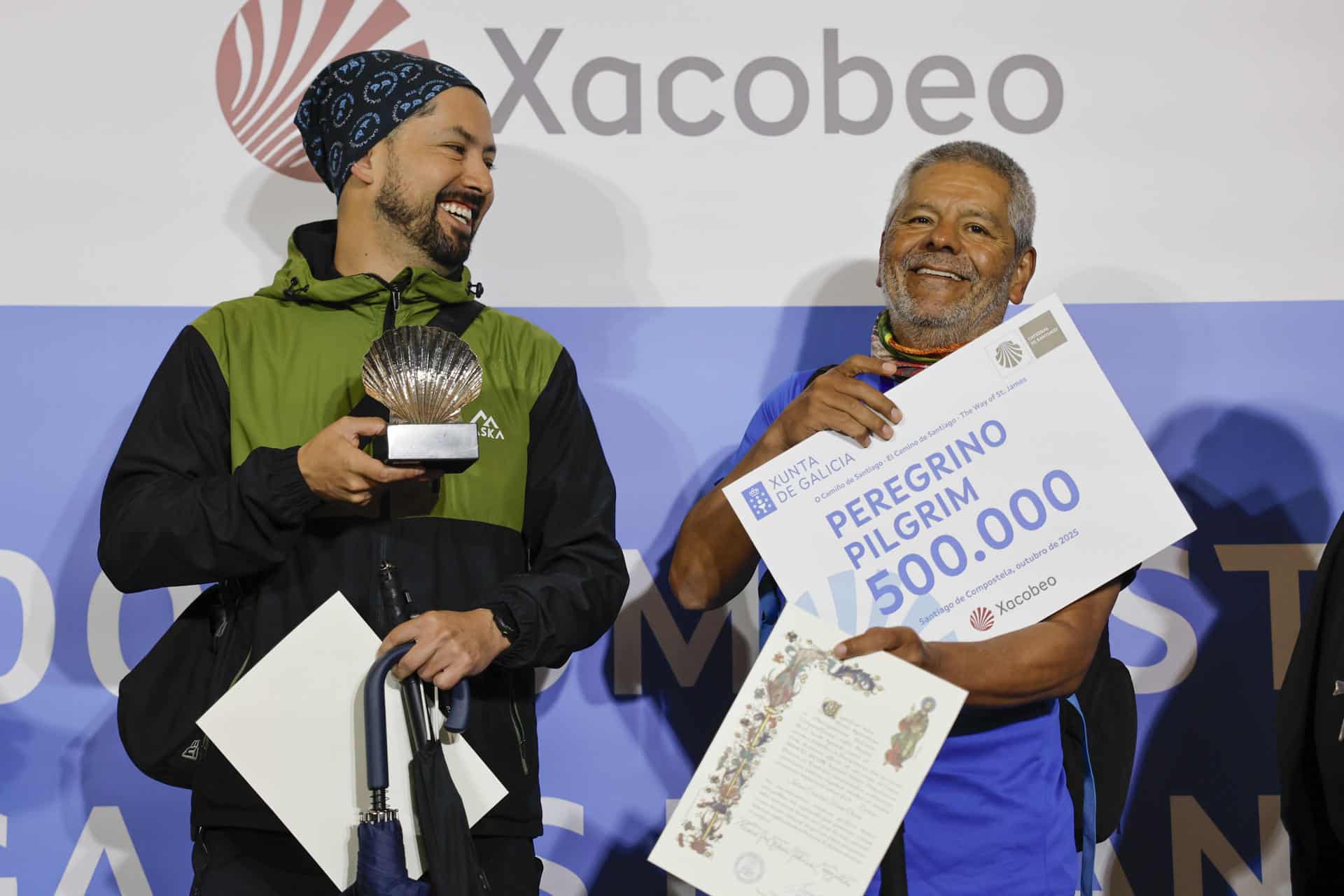 El colombiano Jairo Forero y su hijo Nicolás con el certificado del peregrino 500.000 del Camino de Santiago en la ciudad de Santiago de Compostela (España) . EFE/Lavandeira jr.