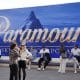La gente se sienta frente a una pancarta de Paramount. EFE/EPA/Sebastien Nogier
