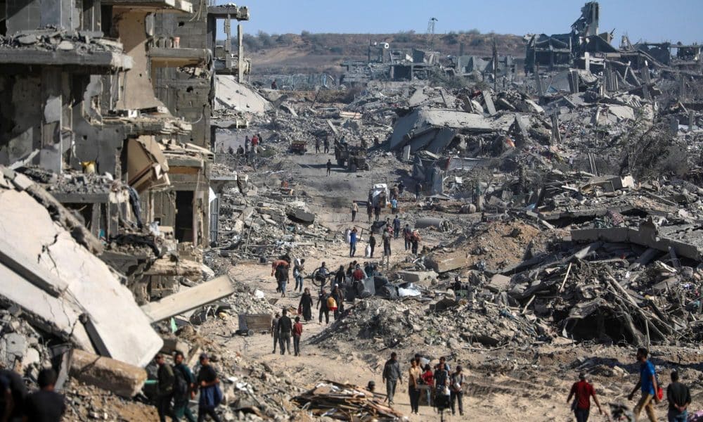 Foto del pasado día 11 de octubre en la que se ve a desplazados internos en Gaza caminando entre los escombros y los edificios destrozados de Ciudad de Gaza. EFE/EPA/MOHAMMED SABER