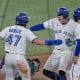 George Springer (c), el héroe de los Azulejos, celebra con sus compañeros Addison Barger (i) y Isiah Kiner-Falefa (d) tras batear un jonrón de 3 carreras contra los Marineros en Toronto (Canadá). EFE/EPA/EDUARDO LIMA