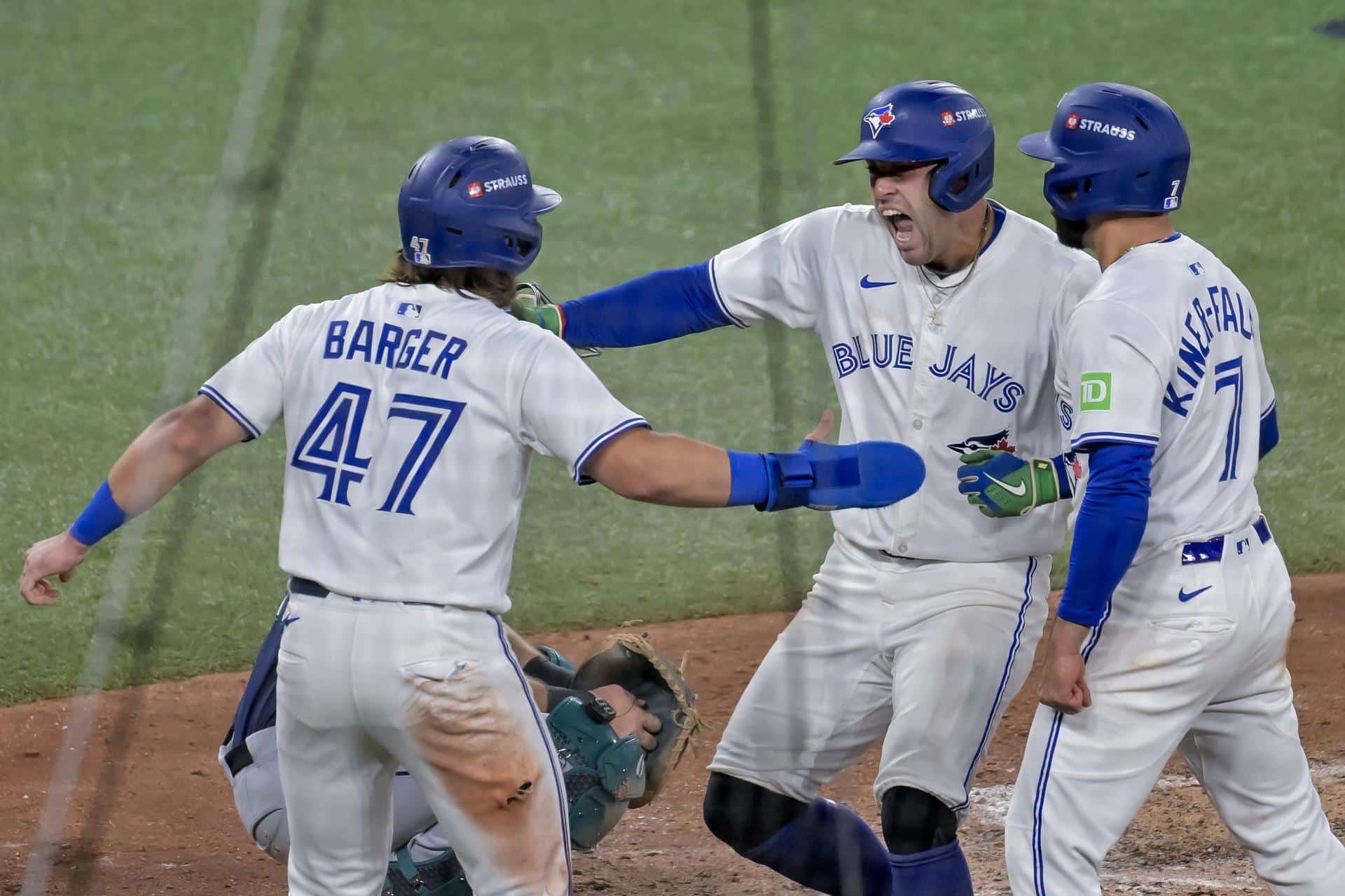 George Springer (c), el héroe de los Azulejos, celebra con sus compañeros Addison Barger (i) y Isiah Kiner-Falefa (d) tras batear un jonrón de 3 carreras contra los Marineros en Toronto (Canadá). EFE/EPA/EDUARDO LIMA
