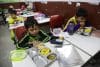 Un estudiante indonesio (izq.) en Depok, Java Occidental, Indonesia, observa su almuerzo, financiado por un programa gubernamental de comida escolar gratuita, el 19 de agosto de 2025. EFE/EPA/BAGUS INDAHONO
