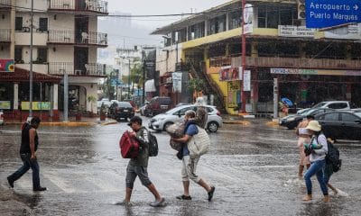 Personas caminan por una calle encharcada debido a las fuertes lluvias en el balneario de Acapulco, estado de Guerrero (México). Imagen de archivo. EFE/David Guzmán