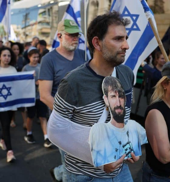 Un hombre porta una foto del difunto rehén israelí Guy Illouz mientras los dolientes escoltan su ataúd durante su procesión fúnebre en Rishon LeZion, Israel, el 15 de octubre de 2025. EFE/ABIR SULTAN