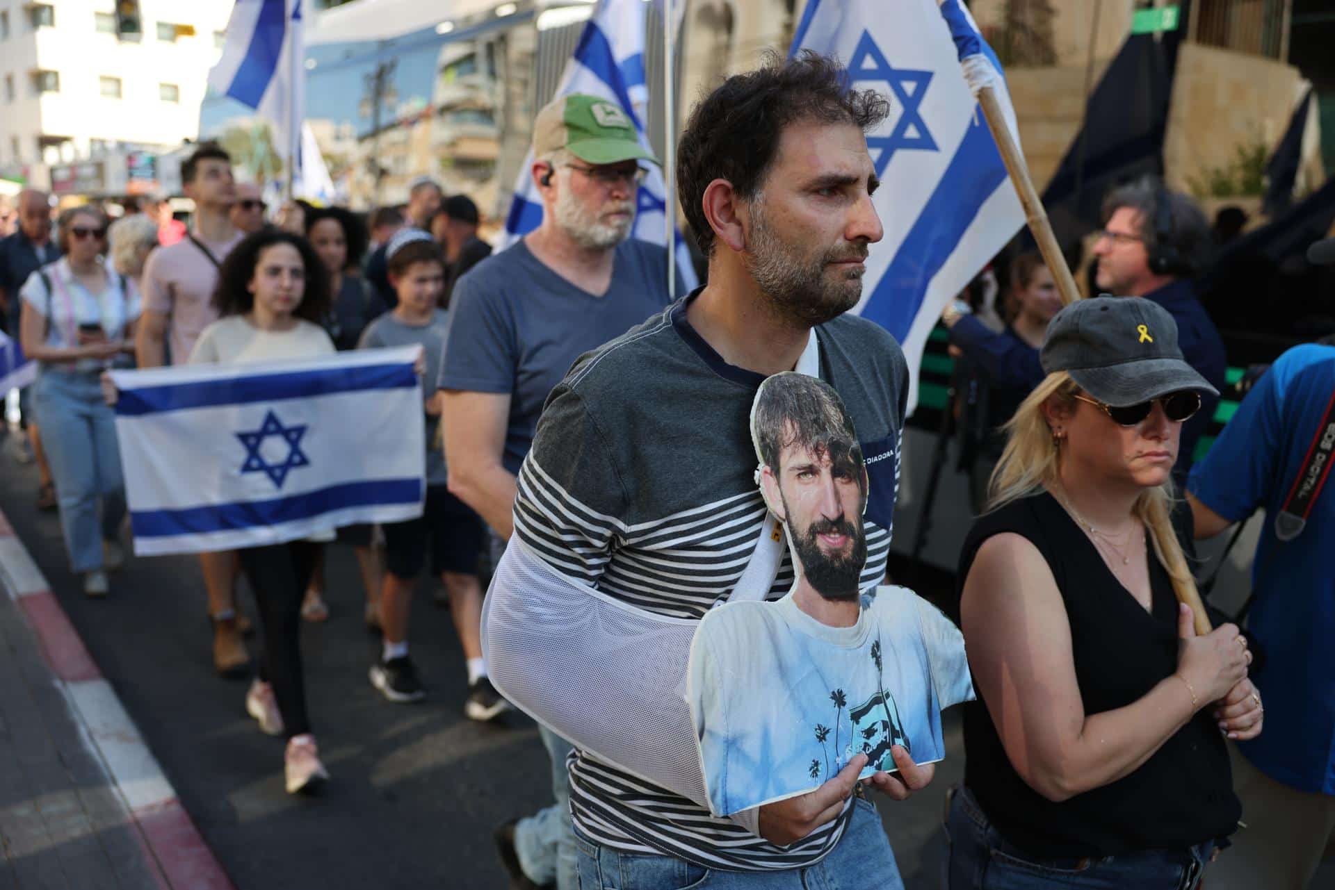 Un hombre porta una foto del difunto rehén israelí Guy Illouz mientras los dolientes escoltan su ataúd durante su procesión fúnebre en Rishon LeZion, Israel, el 15 de octubre de 2025. EFE/ABIR SULTAN