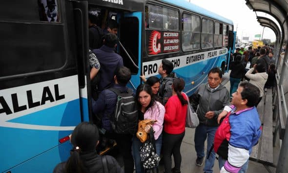 Personas intentan subir a un bus de servicio público este lunes, en Lima (Perú). EFE/ Paolo Aguilar