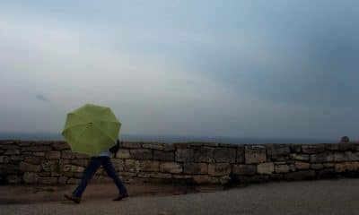 Una mujer camina con un paraguas durante una tormenta en Kaliakra, a unos 500 kilómetros de Sofía (Bulgaria). EFE/Vassil Donev