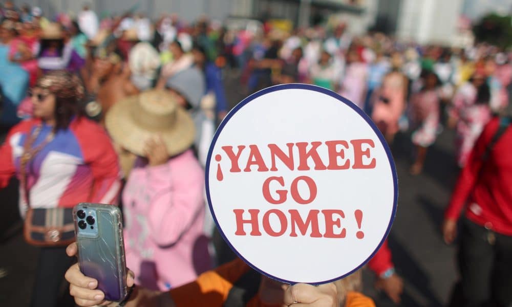Una persona sostiene un cartel durante un acto del Día de la Resistencia Indígena este domingo, en Caracas (Venezuela). EFE/ Miguel Gutierrez