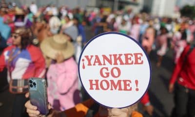 Una persona sostiene un cartel durante un acto del Día de la Resistencia Indígena este domingo, en Caracas (Venezuela). EFE/ Miguel Gutierrez