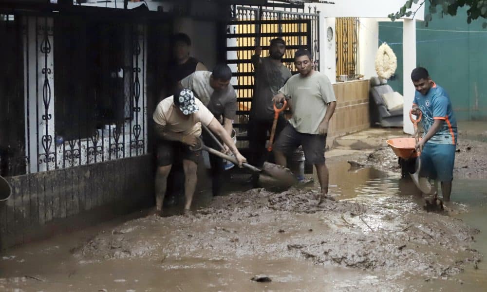 Habitantes de las zonas afectadas por las fuertes lluvias retiran lodo de sus viviendas el domingo 12 de octubre, en Huauchinango (México). EFE/ Hilda Ríos