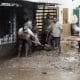 Habitantes de las zonas afectadas por las fuertes lluvias retiran lodo de sus viviendas el domingo 12 de octubre, en Huauchinango (México). EFE/ Hilda Ríos