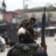 Fotografía que muestra un mono sobre la cabeza de un integrante de la Policía de Río de Janeiro durante un operativo este martes, en Río de Janeiro (Brasil). Al menos veinte personas murieron y medio centenar fueron detenidas en medio de una gran operación policial contra el Comando Vermelho, una de las más poderosas bandas del crimen organizado de Río de Janeiro.EFE/ Antonio Lacerda