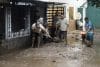 Habitantes de las zonas afectadas por las fuertes lluvias retiran lodo de sus viviendas este domingo, en Huauchinango (México). EFE/ Hilda Ríos
