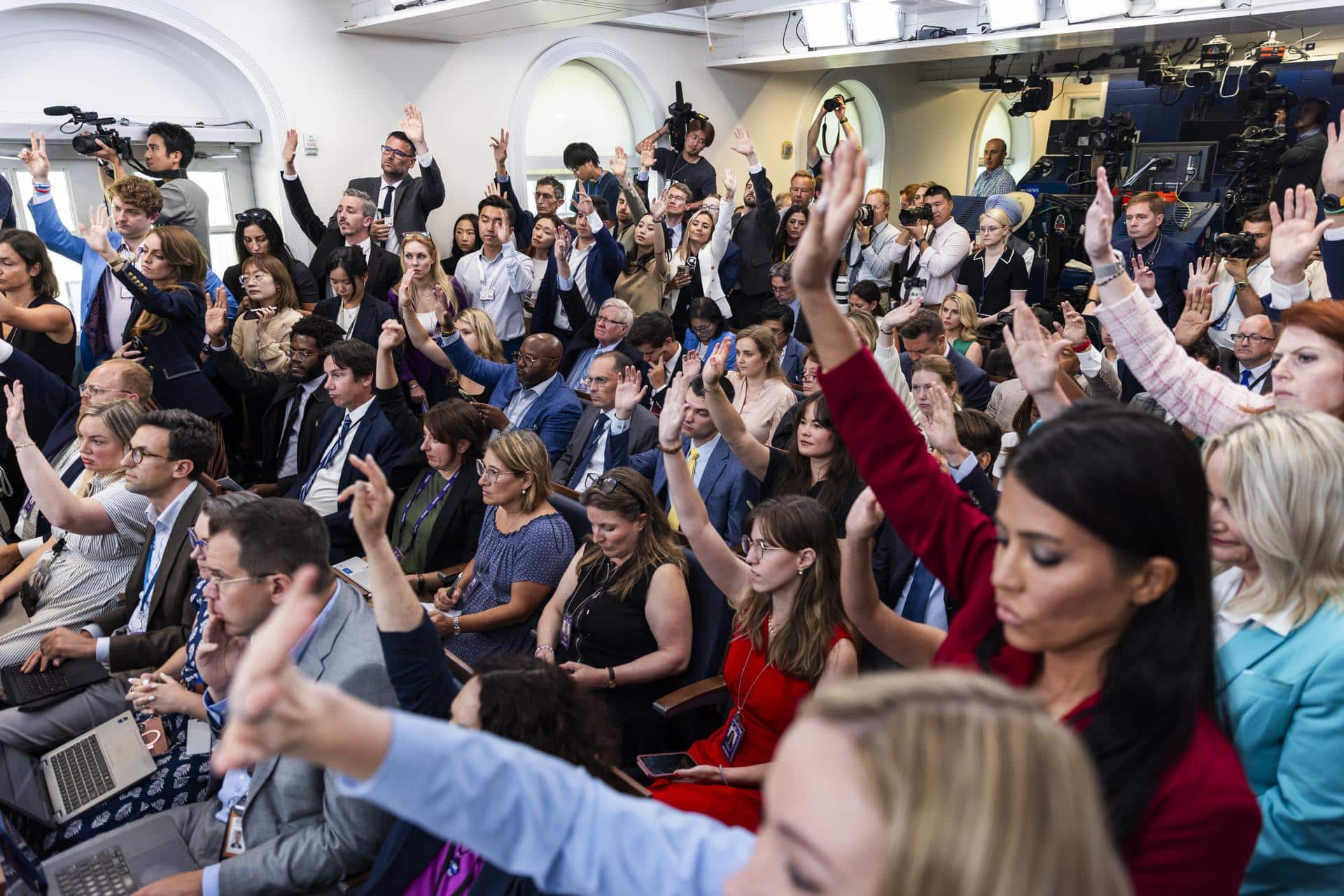 Foto de archivo que muestra a miembros del cuerpo de prensa de la Casa Blanca levantando la mano para hacer preguntas durante una rueda de prensa en la Sala de Prensa de la Casa Blanca. EFE/EPA/JIM LO SCALZO