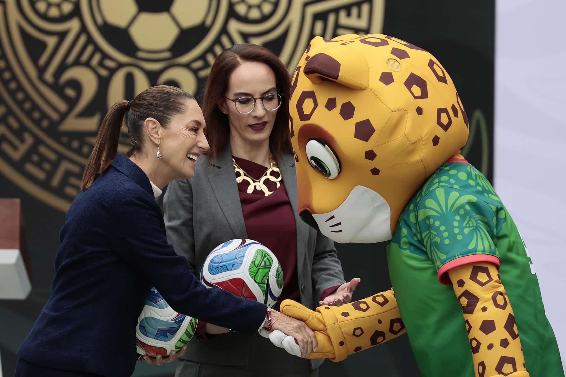 La presidenta de México Claudia Sheibaum (i) saluda al jaguar Zayu (d), mascota de México para la Copa Mundial de la FIFA 2026 durante una rueda de prensa este lunes, en el Complejo Cultural Los Pinos de la Ciudad de México (México). EFE/José Méndez